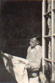 Eugene O'Neill sitting, reading newspaper